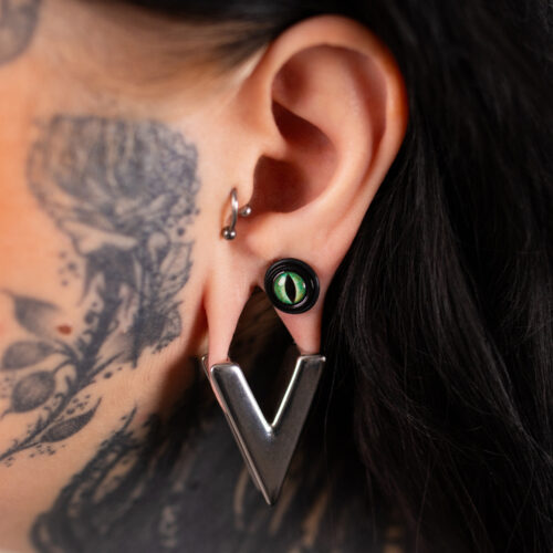 Coppia di Fake Plug in PMMA nero con dettaglio verde indossata all'orecchio