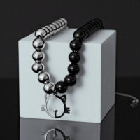 Collana di perle argento-nero con ciondolo a forma di gatto su cubo bianco