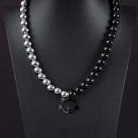 Collana in argento e nero con ciondolo a forma di gatto su sfondo nero
