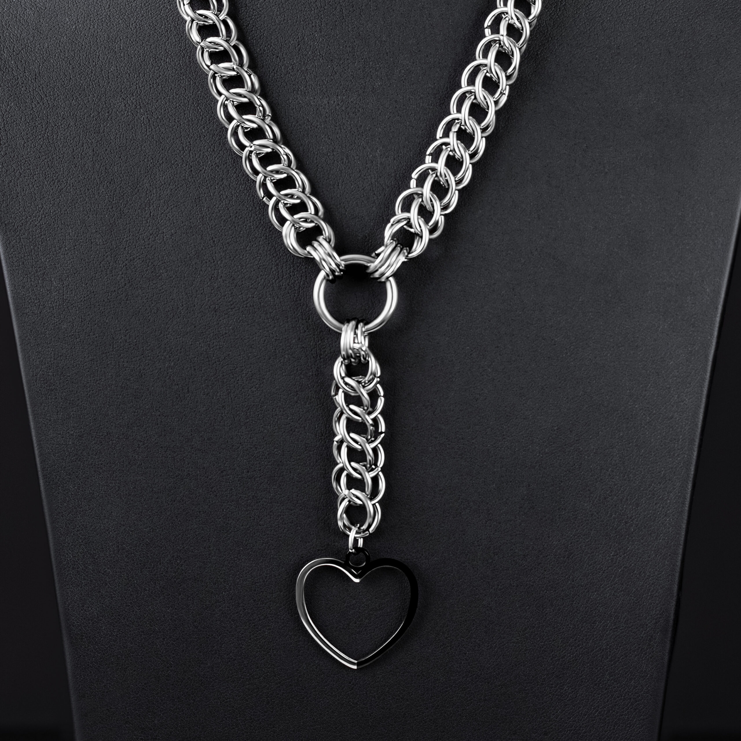 Collana choker argentata con grande ciondolo a cuore su sfondo nero