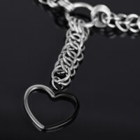 Collana choker argento con grande ciondolo a cuore su sfondo nero