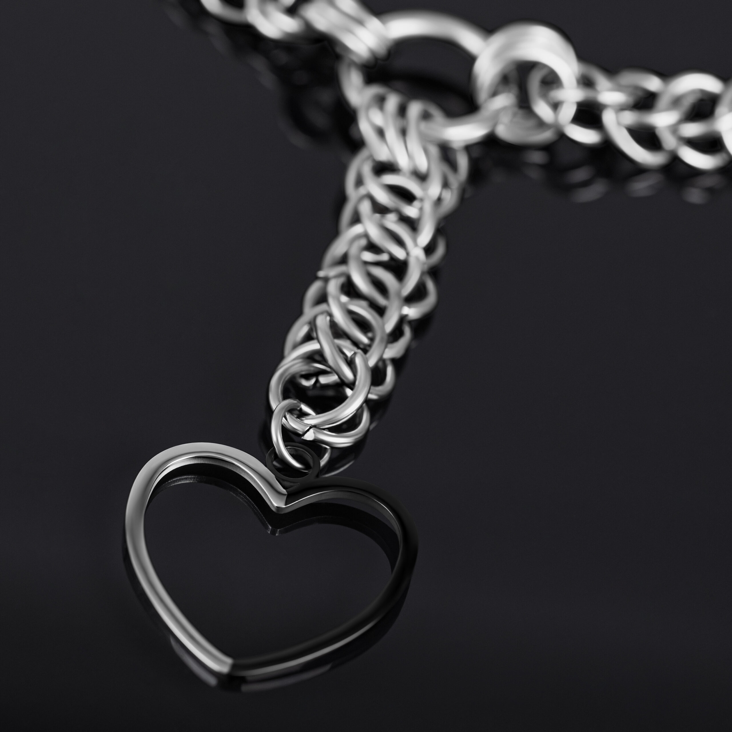 Collana choker argento con grande ciondolo a cuore su sfondo nero