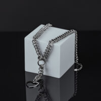 Collana d'argento con ciondolo a cuore su cubo grigio davanti a sfondo nero