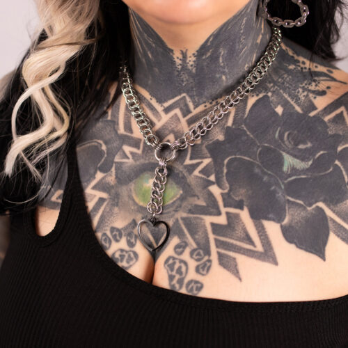 Collana choker argento con ciondolo a cuore su pelle tatuata