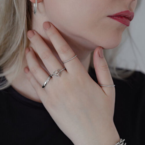 Donna indossa diversi anelli, incluso un Eye Ring in argento su sfondo chiaro