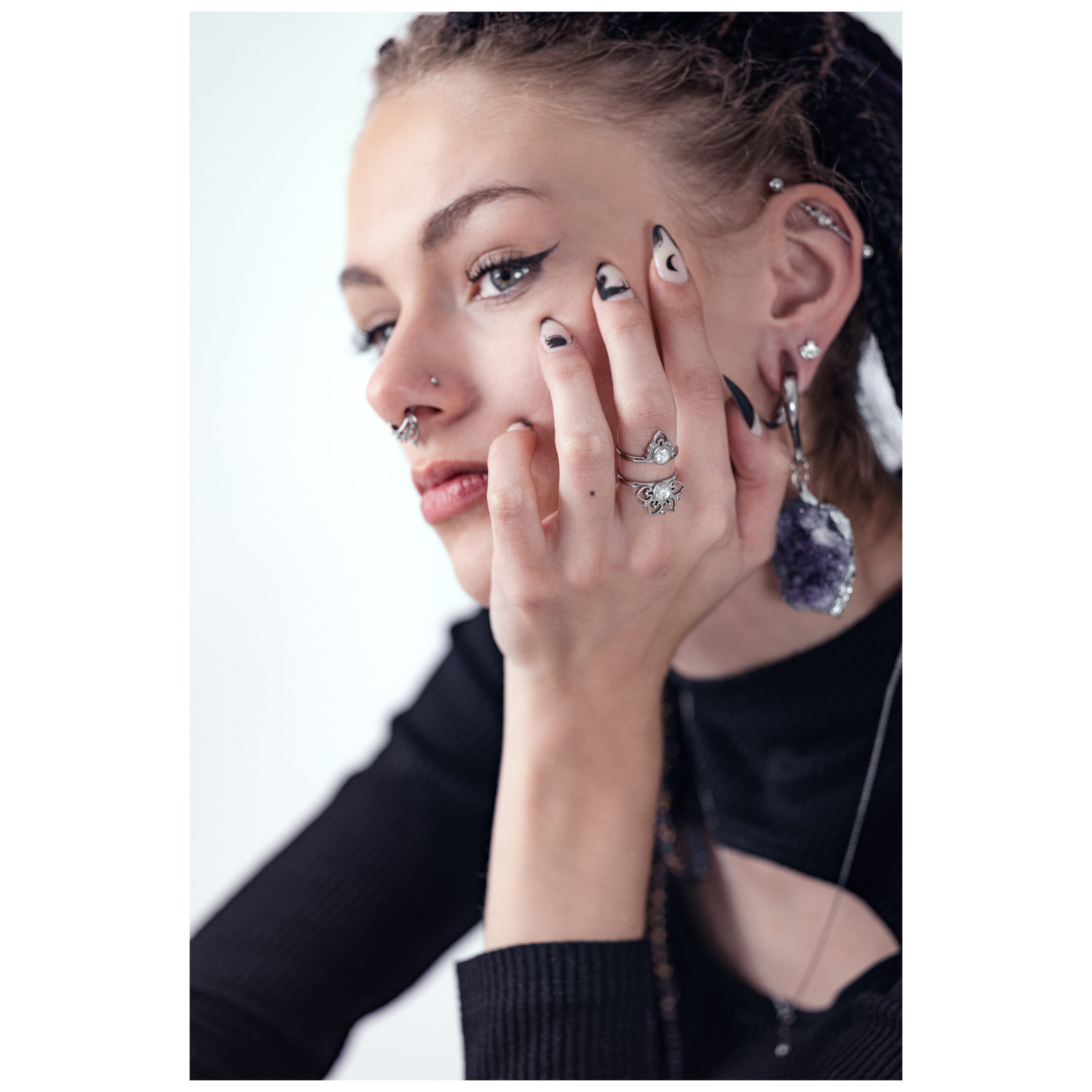 Donna con anello d'argento Silver Sun Tides, mano sul viso, top nero