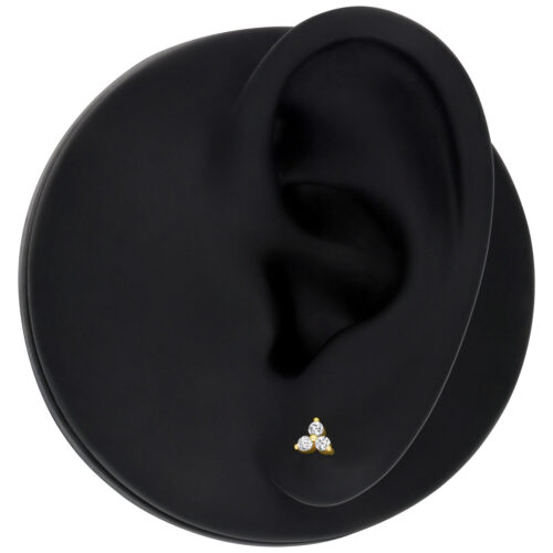 Attacco Trinity per piercing in oro 14K con cristalli chiari su modello di orecchio nero