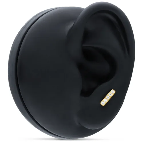 Accessorio per piercing all'orecchio in oro con 5 cristalli chiari su sfondo nero