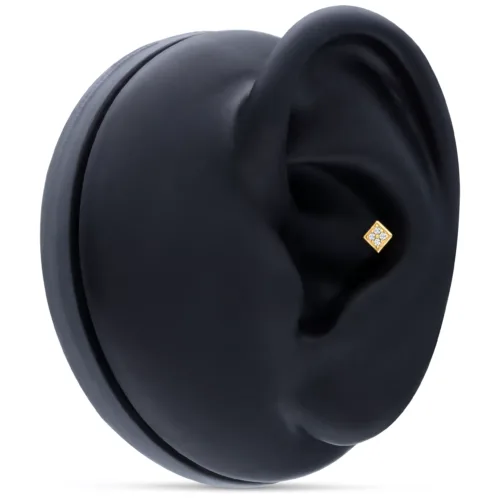 Accessorio quadrato in oro su display nero per orecchio