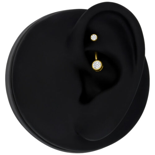 Piercing dorato con cristallo chiaro su modello d'orecchio nero