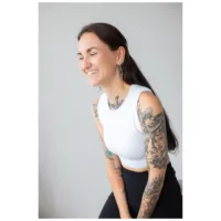 Donna con capelli lunghi e tatuaggi indossa orecchini Thunderbolt Hoops, top bianco