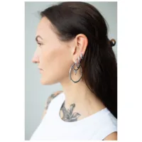 Donna con lunghi capelli scuri indossa grandi orecchini a cerchio in argento