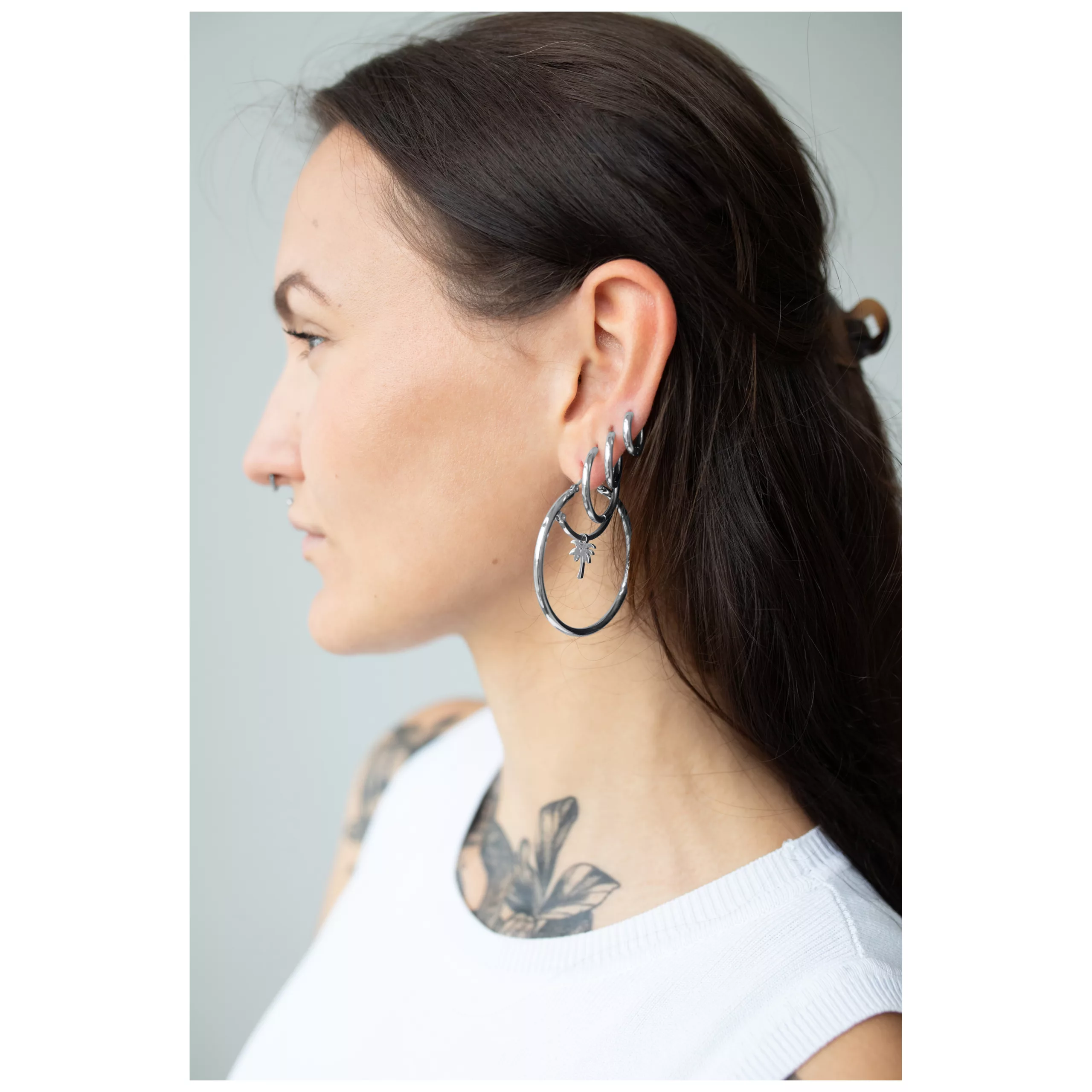 Donna con lunghi capelli scuri indossa grandi orecchini a cerchio in argento