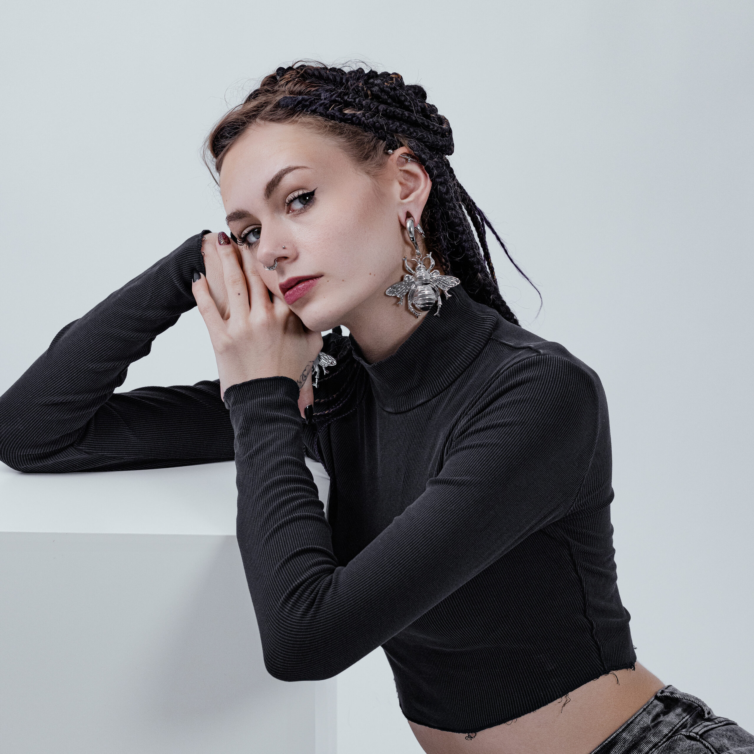 Bee Pesi per orecchie in acciaio chirurgico, argento Donna con pesi per orecchie Bee in argento, maglione a collo alto nero, sfondo chiaro