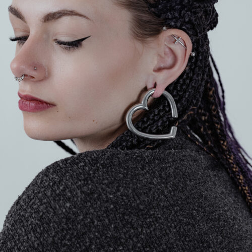 Donna con pesi per orecchie a forma di cuore in acciaio nero