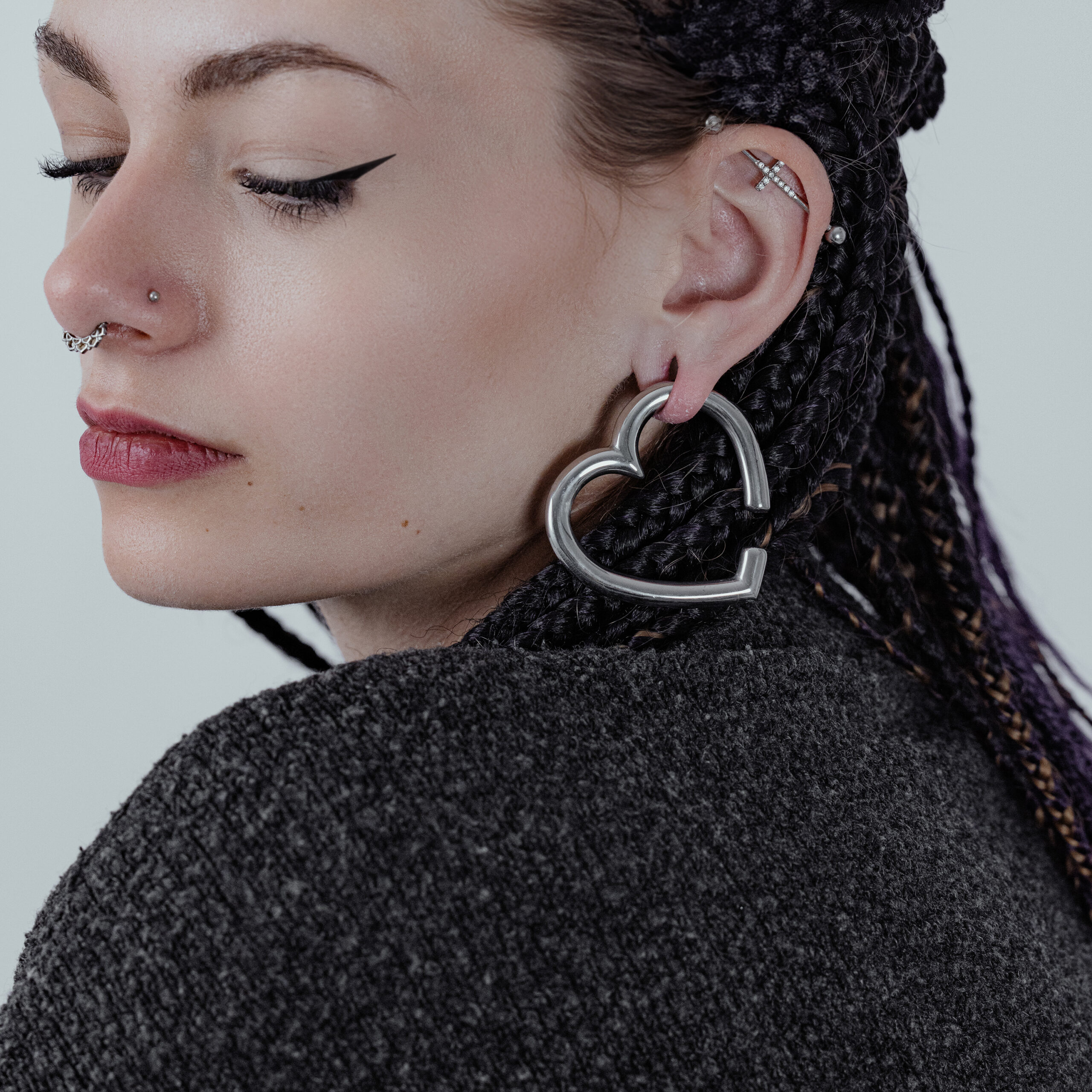 Donna con pesi per orecchie a forma di cuore in acciaio nero