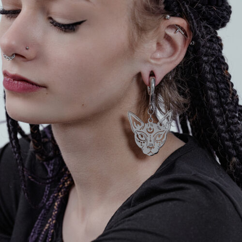 Donna con capelli intrecciati indossa un peso per orecchie Sphynx in argento.