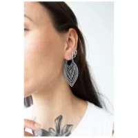 Donna con orecchini Creek Hoops in argento, indossati all'orecchio, sfondo bianco