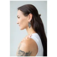 Donna con capelli lunghi indossa orecchini Creek Hoops in argento su sfondo neutro