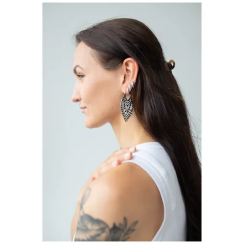 Donna con capelli lunghi indossa orecchini Creek Hoops in argento su sfondo neutro