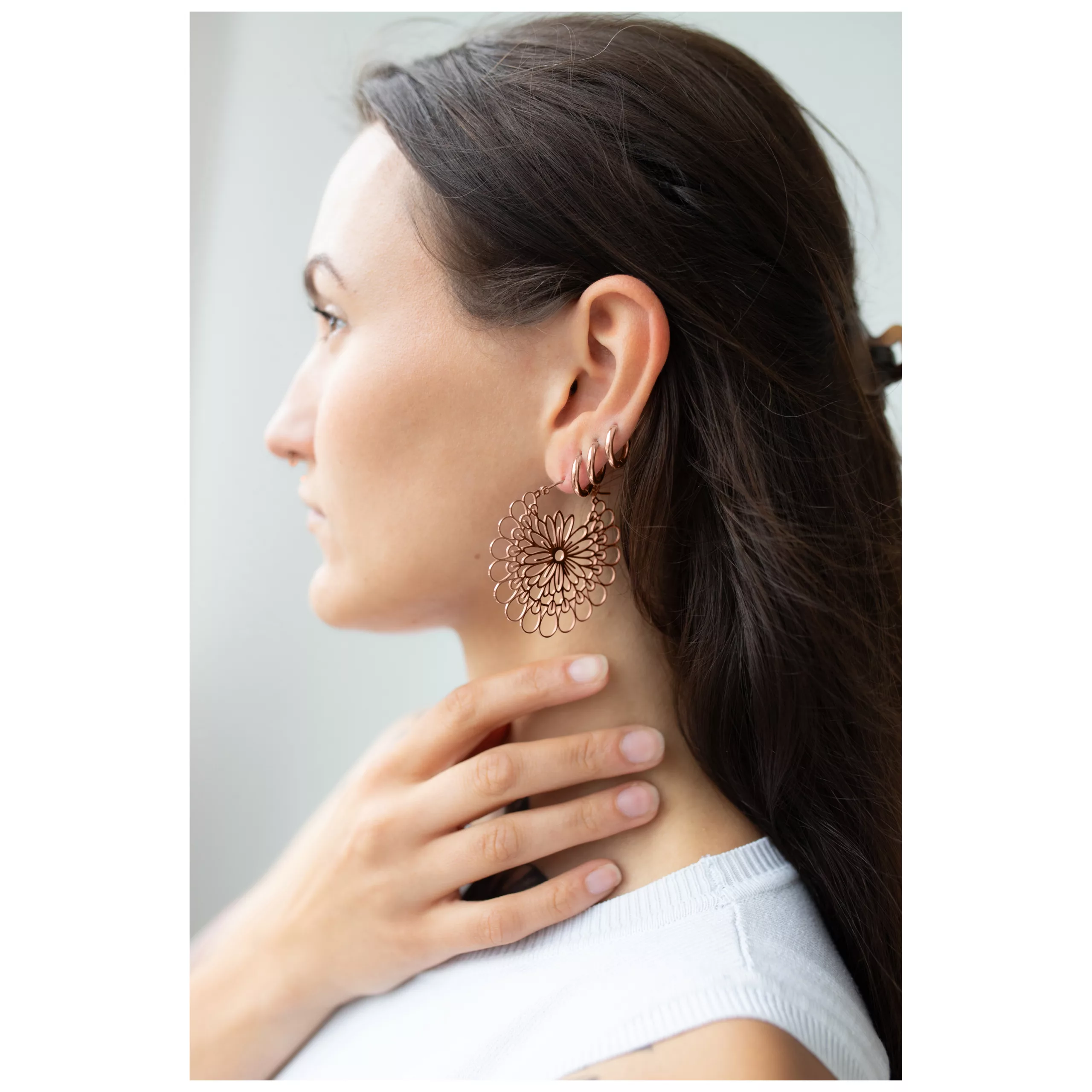 Donna con orecchini Daisy Hoops in oro rosa all'orecchio, profilo laterale