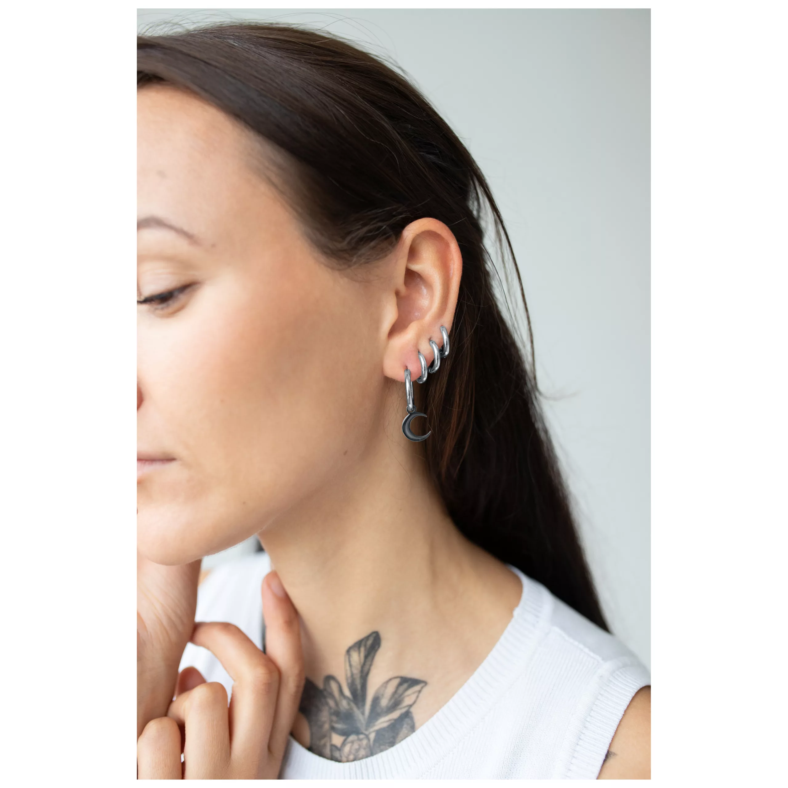 Donna con Little Moonchild Hoops neri, indossati lateralmente all'orecchio