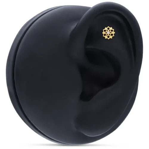 Piccolo accessorio d'oro a forma di caleidoscopio nell'orecchio su sfondo nero