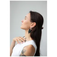 Donna con lunghi capelli scuri indossa orecchini Smiley Big Hoops in argento