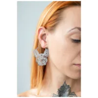 Orecchini Bulldog in argento sull'orecchio di una donna con capelli chiari e tatuaggio