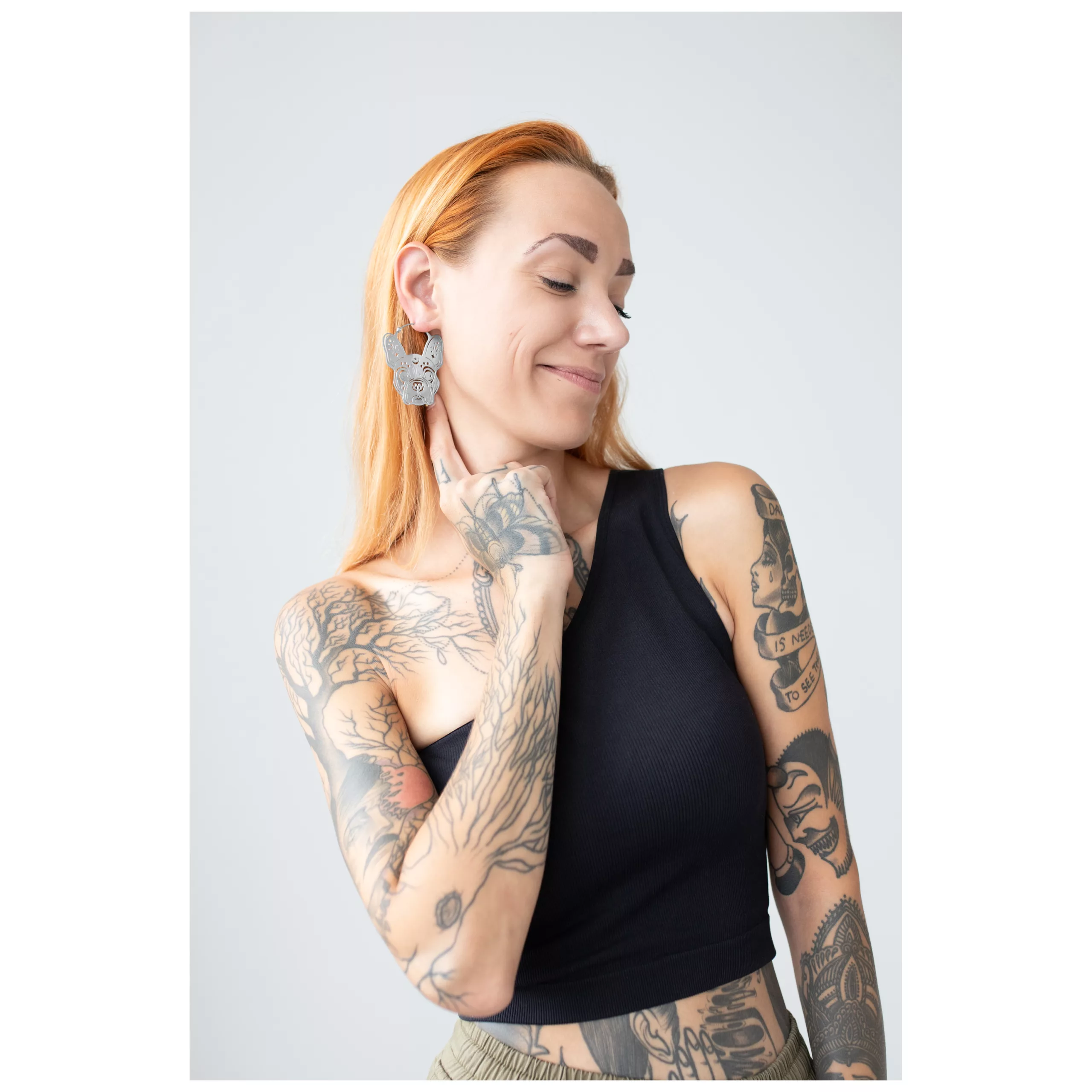 Donna con tatuaggi indossa grandi orecchini Bulldog Hoops