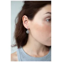 Donna che indossa orecchini d'argento con motivo a occhi, vista laterale