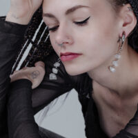 Donna con pesi per orecchie Rocks in argento e piercing al naso