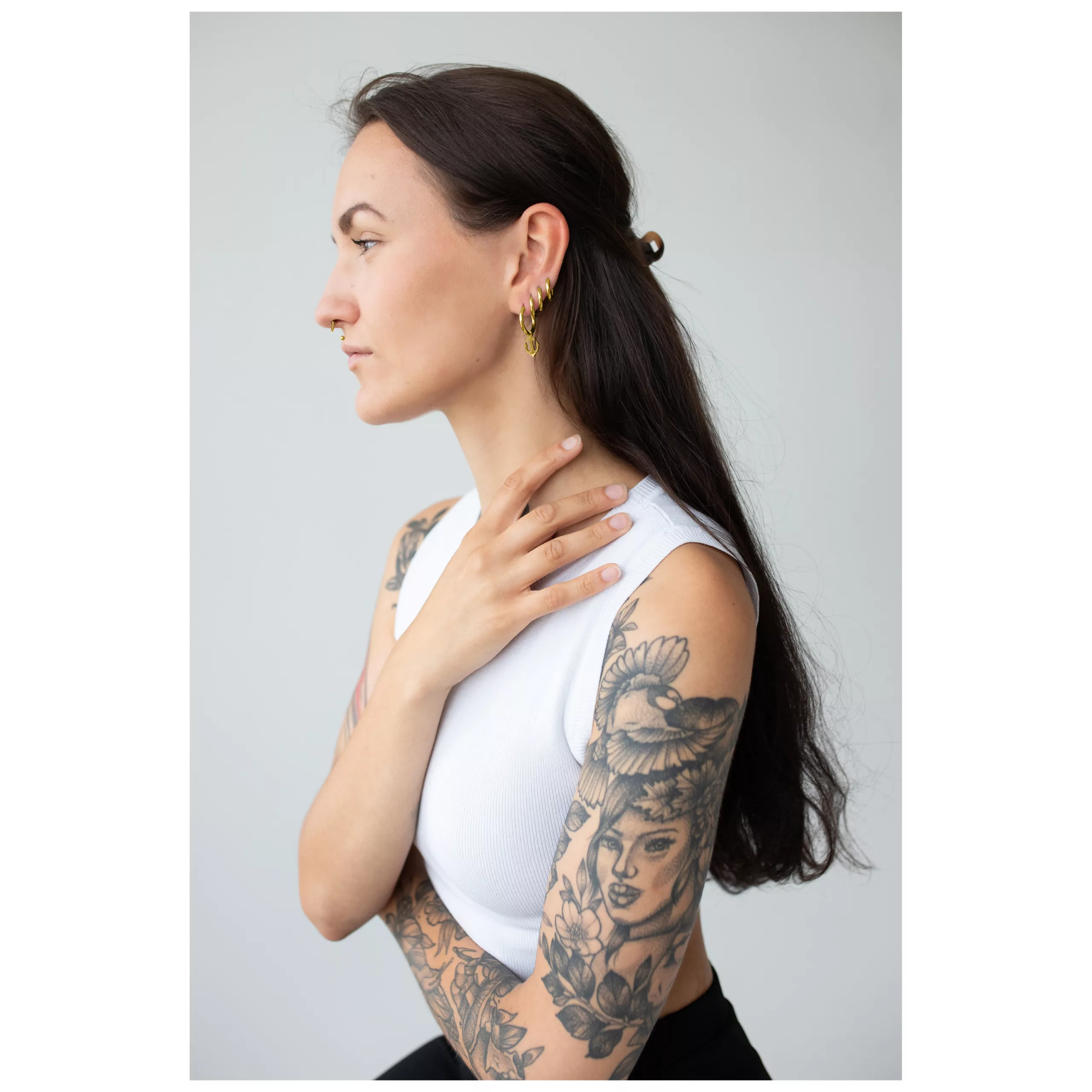Donna con capelli lunghi indossa orecchini Little Anchor dorati, profilo laterale