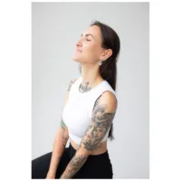 Donna con braccia tatuate indossa Little Bulldog Hoops neri su sfondo grigio