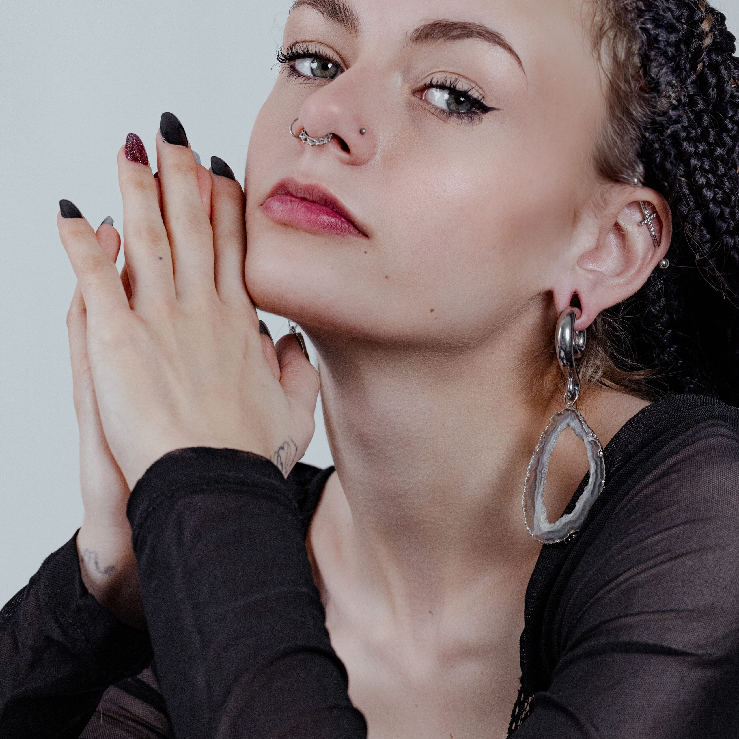 Donna con capelli intrecciati indossa grandi pesi per orecchie Indian Agate Stone in argento e oro.