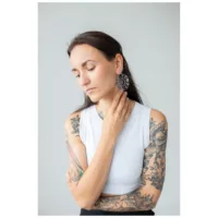 Donna con grandi orecchini rotondi in nero e argento, su sfondo grigio