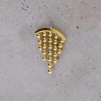 Punta per piercing helix color oro con sfere pendenti su sfondo chiaro