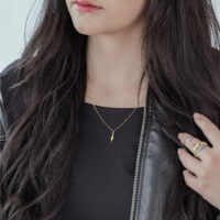 Donna con collana Little Snake dorata, abito nero, capelli lunghi