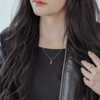 Donna con collana Little Snake in oro rosa in acciaio chirurgico, outfit nero