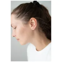 Donna con orecchini in oro rosa Double Beam Crystal su sfondo grigio