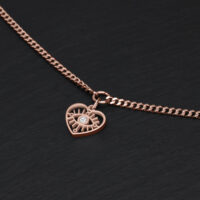 Bracciale in oro rosa con ciondolo a cuore e cristallo chiaro su sfondo nero
