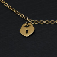 Bracciale dorato con lucchetto a forma di cuore su sfondo nero