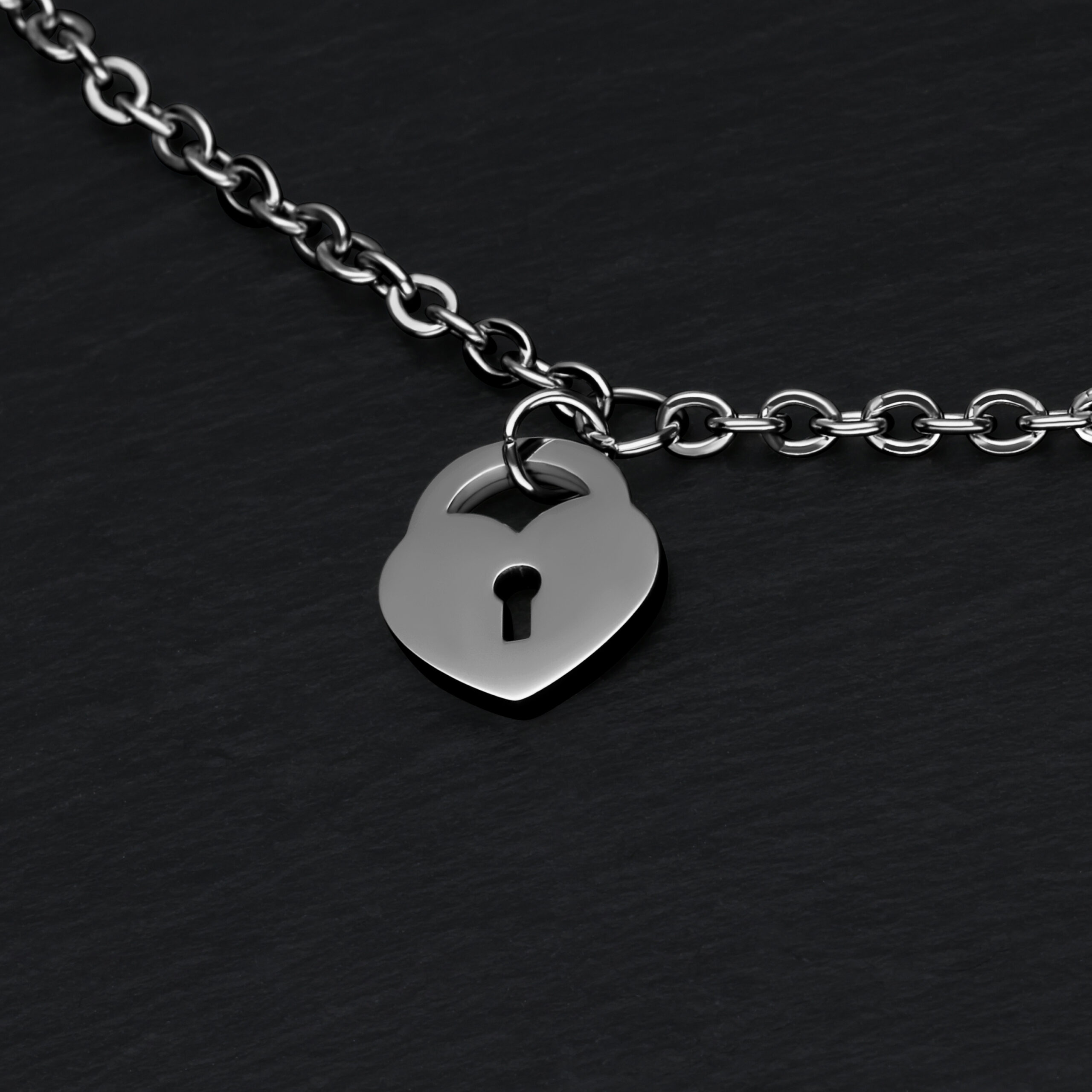 Bracciale argento con ciondolo a lucchetto a cuore su sfondo nero