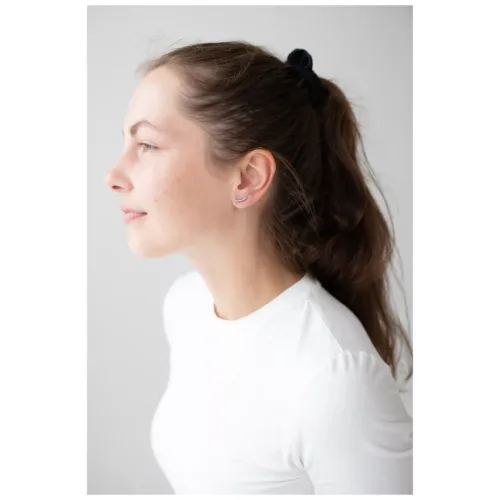 Donna con orecchini a arco di cristallo e maglia bianca