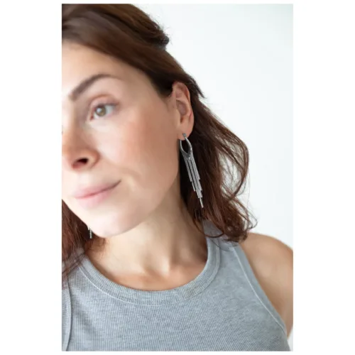 Donna con orecchini Snakechain Hoops in argento su sfondo bianco