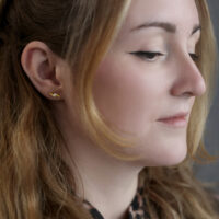 Donna con barbell per orecchio dorato Crystal Flashlight, sfondo grigio