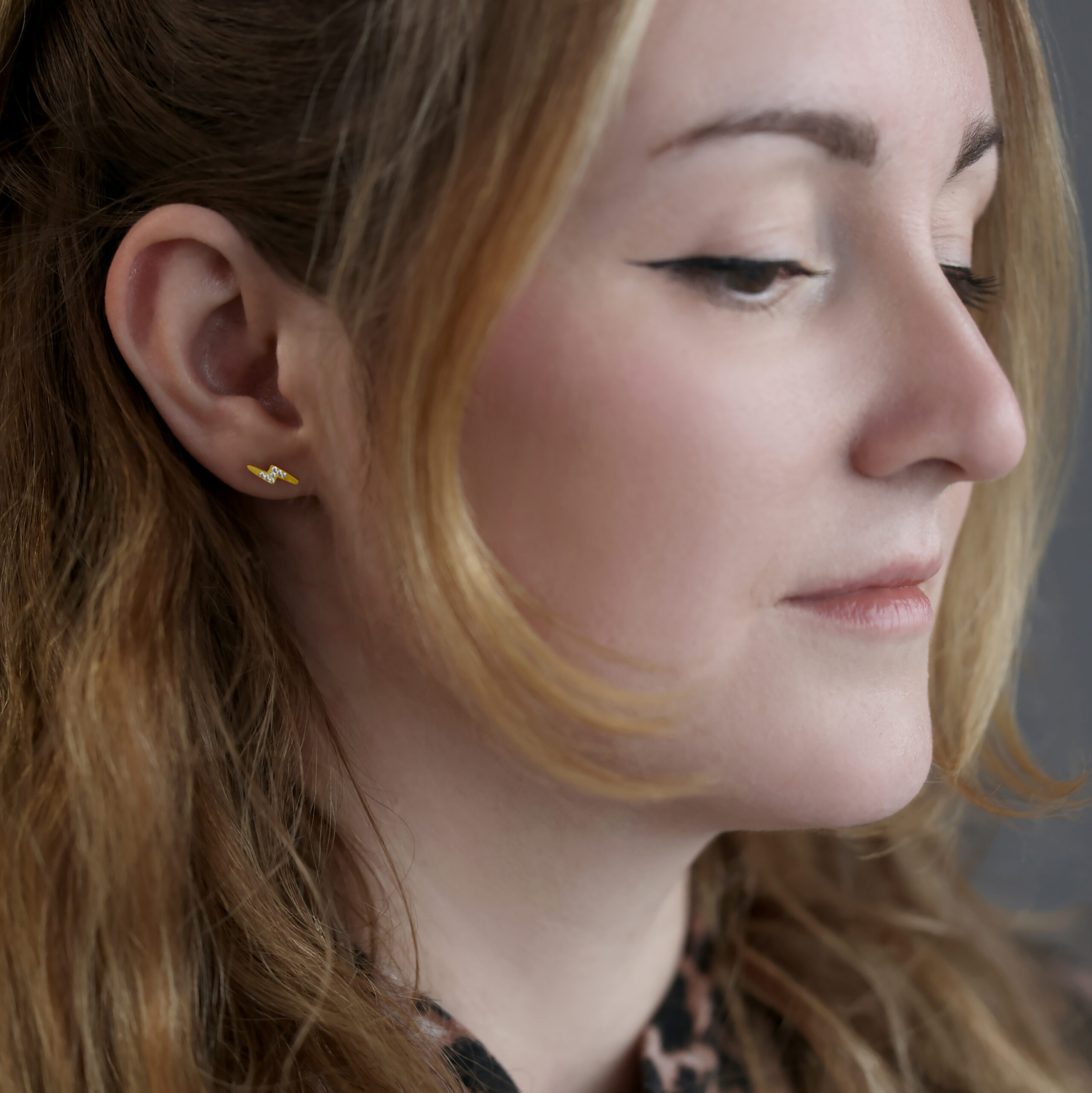 Donna con barbell per orecchio dorato Crystal Flashlight, sfondo grigio