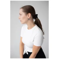 Donna con maglietta bianca indossa Little Soulmate Hoops in argento su sfondo grigio