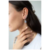 Orecchini a forma di serpente argento all'orecchio di una donna su sfondo chiaro