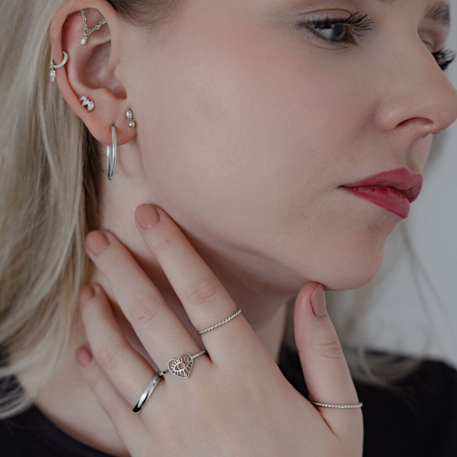Donna con diversi orecchini che indossa un Twisted Ring in argento